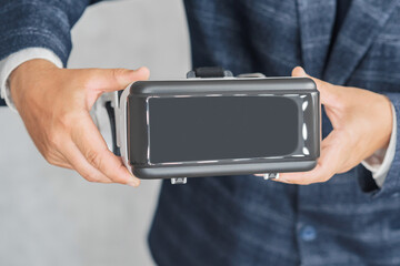 Virtual reality glasses, close-up in the hands of a man. On a light background.