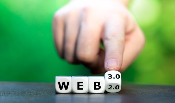 Hand turns dice and changes the expression "web 2.0" to "web 3.0".