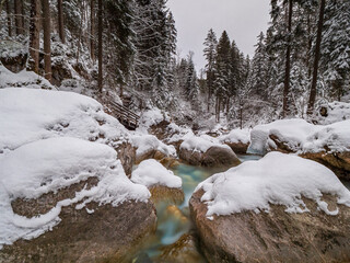 Berchtesgaden Zauberwald with the turquoise water river during winter
