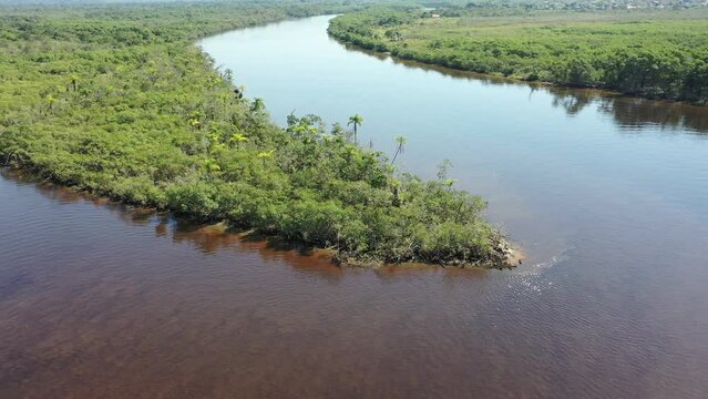 Panning wide view of peaceful darm river at coastal city of Itanhaem Sao Paulo Brazil. South coast of state of Sao Paulo. Tropical scenery. Travel destinations. Popular tourism landmark.
