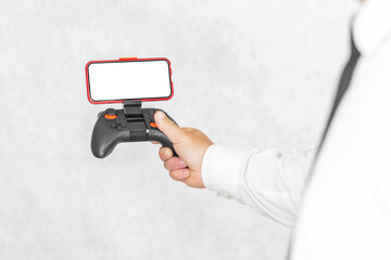 Joystick with a smartphone mockup in the hands of a guy. On a light background. © Victor