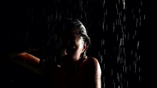 alluring woman in shower, sensual shot in darkness, slow motion, portrait