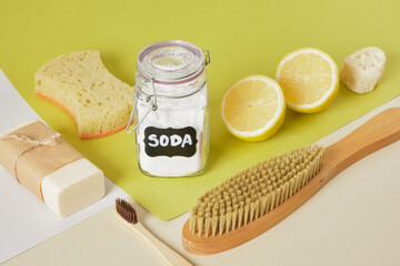 soap, sponge, soda in a labeled jar, lemon and a wooden brush