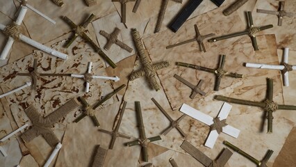 Wooden crucifixes cross on the ancient parchment paper. Handmade religion Christ crosses items made of forest twigs and sticks. Jesus Christ son of God prayer on old weathered burnt textured paper.