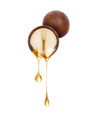 Drops of oil dripping from half of macadamia nut close up