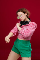 Obraz premium portrait of a girl in green shorts glasses with diamond headphones posing