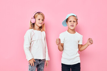 Stylish little boy and cute girl dancing entertainment pink color background