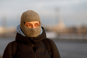 Fototapeta na wymiar Portrait of a woman in a balaclava in sunny weather in winter
