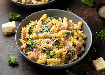 Fusilli pasta with bacon, kale and parmesan cheese. Healthy food