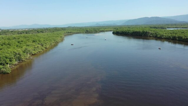 Panning wide view of peaceful darm river at coastal city of Itanhaem Sao Paulo Brazil. South coast of state of Sao Paulo. Tropical scenery. Travel destinations. Popular tourism landmark.