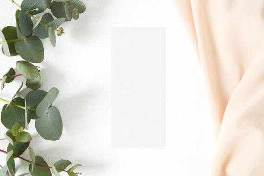 Mockup menu card with eucalyptus leaf and nude fabric