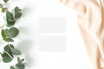Mockup business card with eucalyptus leaves and nude fabric