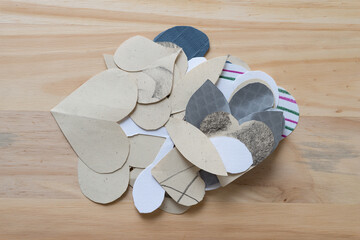 pile of paper with various shapes (hearts) on a wooden surface