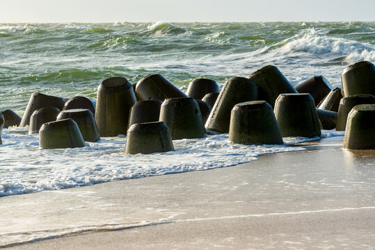 Storm on the North Sea, waves hitting the breakwater concrete tetrapods on the beach, Sylt, Germany