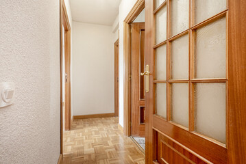 Residential home hallway with mahogany-colored wood and glass doors