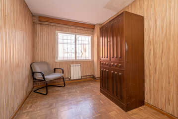 Fototapeta na wymiar Living room with kitschy wallcovering and paneled wooden cabinet