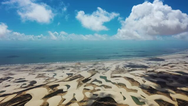Panning wide view of brazilian landmark rainwater lakes and sand dunes. Lencois Maranhenses Maranhao. International travel destinations.