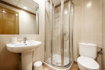 Bathroom with porcelain pedestal sink and recessed rectangular mirror and shower with aluminum...
