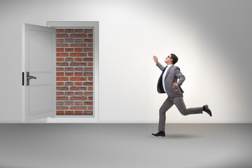 Businessman facing no exit with brick door