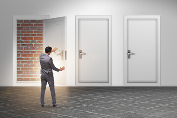 Businessman facing no exit with brick door