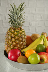 Tray with different ripe fruits on grey table