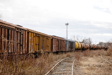 Fototapeta na wymiar Old and rusty cargo train at the train station, train on the railway.