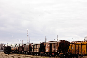Old and rusty cargo train at the train station, train on the railway.