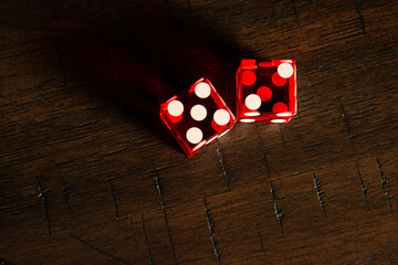 Professional casino-style red dice on a wooden table.