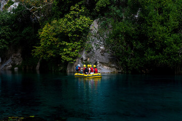Fototapeta na wymiar people on an inflatable boat rafting down the blue water canyon in Goynuk, Turkey
