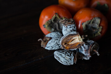 Dried persimmon and fresh persimmon on a wooden background. Healthy diet. Healthy diet