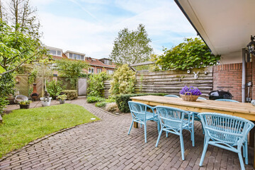 Stunning courtyard house with garden and wicker blue chairs - obrazy, fototapety, plakaty