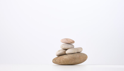 stack of round stones on a white background. Scene for demonstration of cosmetic products