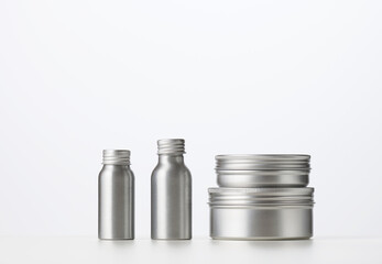 empty silver metal bottle for cosmetics on white table. Packaging for cream, gel, serum,