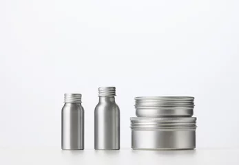 Schilderijen op glas empty silver metal bottle for cosmetics on white table. Packaging for cream, gel, serum, © nndanko