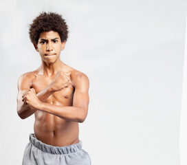Fototapeta premium Strong Athletic handsome teenager afro Fitness Model Torso showing six pack abs. showing his muscles