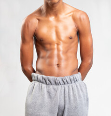 Strong Athletic handsome teenager afro Fitness Model Torso showing six pack abs. showing his muscles