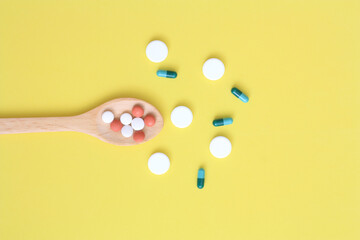 Fototapeta na wymiar color medical capsules on wooden spoon