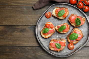 Obraz na płótnie Canvas Delicious sandwiches with salmon and spinach on wooden table, flat lay. Space for text