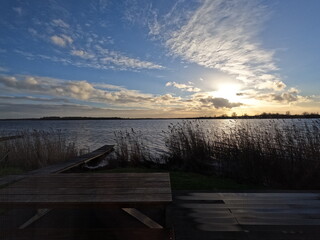 pier at sunset at lake with reed shore