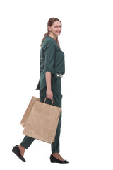 Full length side view of happy young woman walking with shopping bags