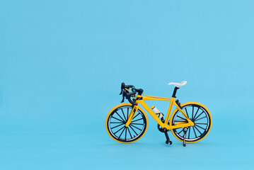Bicicicleta de montaña amarilla aislada sobre fondo azul.