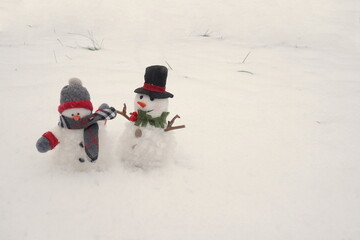 Snowman with Cap and Scarf and Snowman with Top Hat in Snow