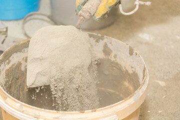 Mixing cement in a bucket. Construction works. To make repairs. Bulk material.