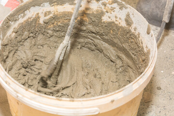 Mixing cement in a bucket. Construction works. To make repairs. Bulk material.