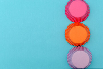 Moldes coloridos de papel para cupcakes sobre fondo azul