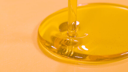 MACRO: Delicious organic extra virgin olive oil starts flowing into a deep dish.