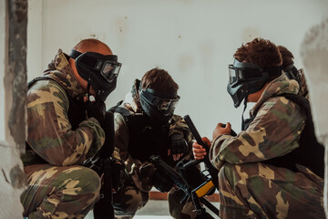 The paintball team agrees on tactics before the fight begins. Selective focus