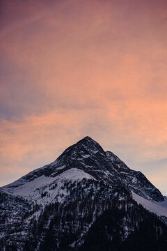 A Vertical Shot Of A Mountain With Soft Pink Sky Background