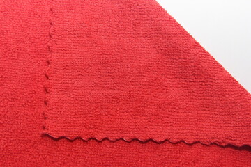 Concept of cleaning of premises, offices and houses. Tools for restoring order and cleanliness. A red microfiber rag with scalloped edges.