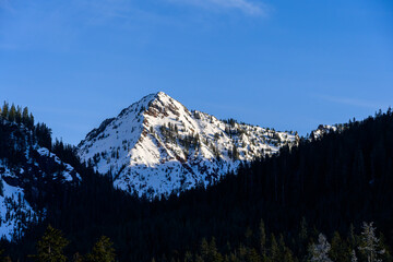 First light on a mountain peak in the Alpine Lakes Wilderness on a clear blue sunny day, as a nature background
